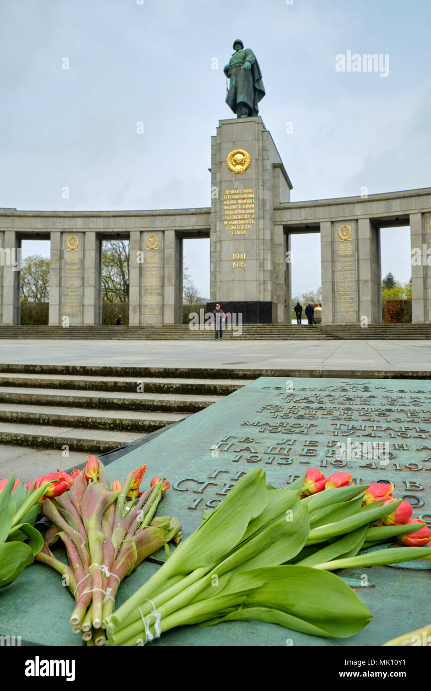 Berlin, Deutschland - 14 April 2018: Tulpen auf dem Grabstein mit Götzen Namen der Sowjetunion Helden vor der Bronzestatue von sowjetischen Soldaten Stockfoto