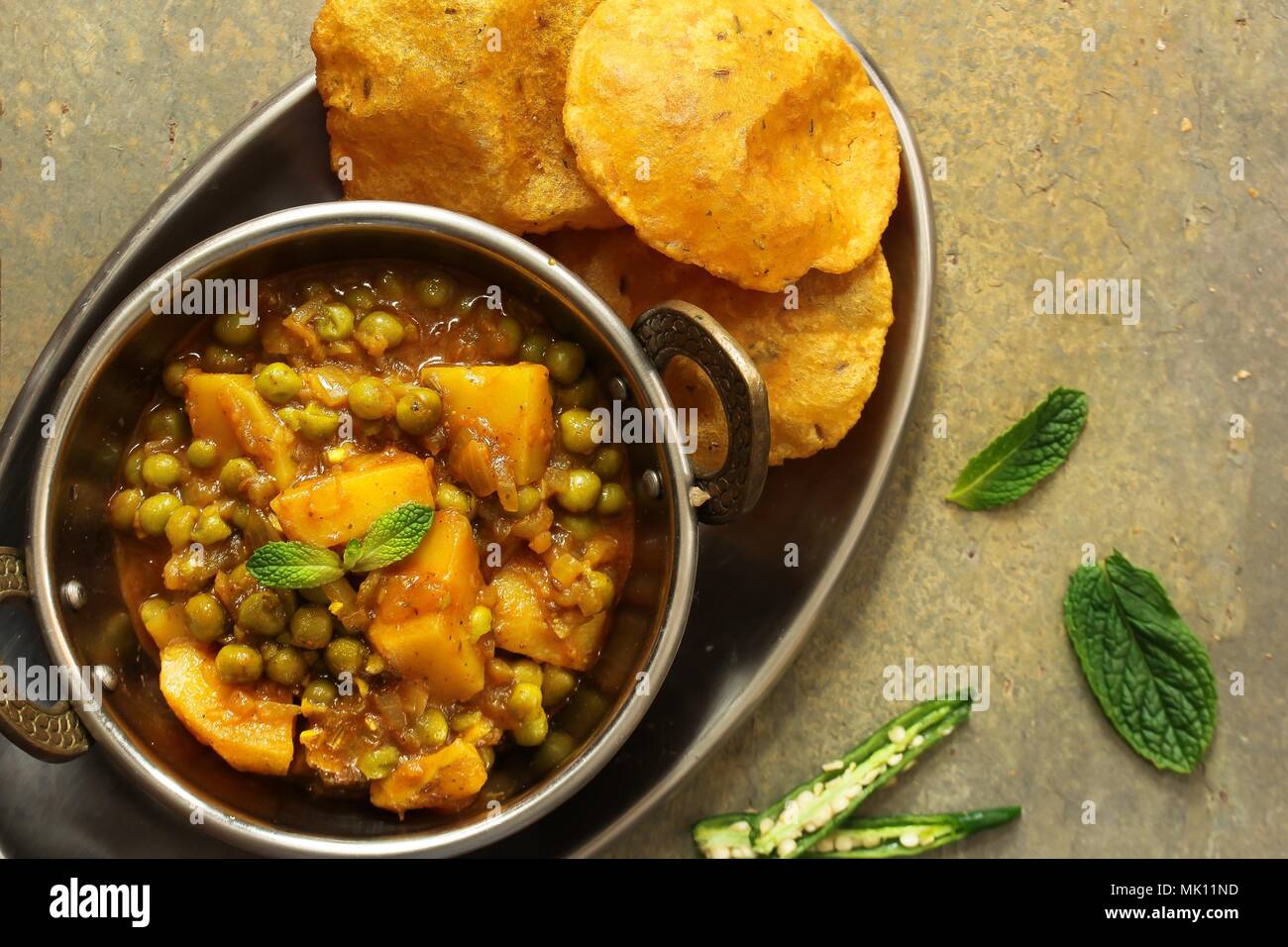 Hausgemachte Aloo Mutter/Alu Matar/Indischen Erbsen Kartoffel curry mit Masala Puri serviert. Stockfoto