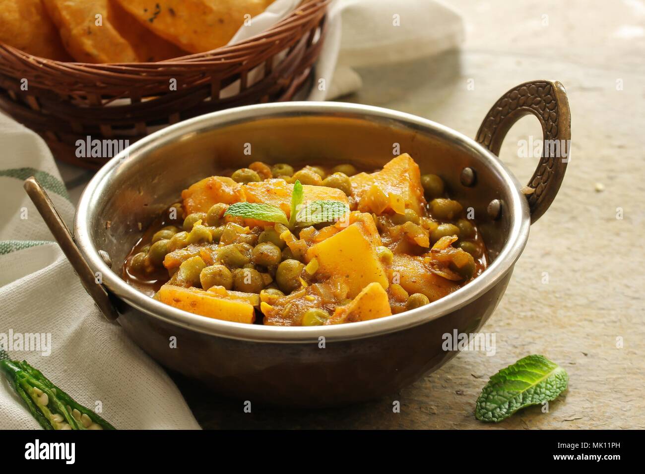 Hausgemachte Aloo Mutter/Alu Matar/Indischen Erbsen Kartoffel curry mit Masala Puri serviert. Stockfoto