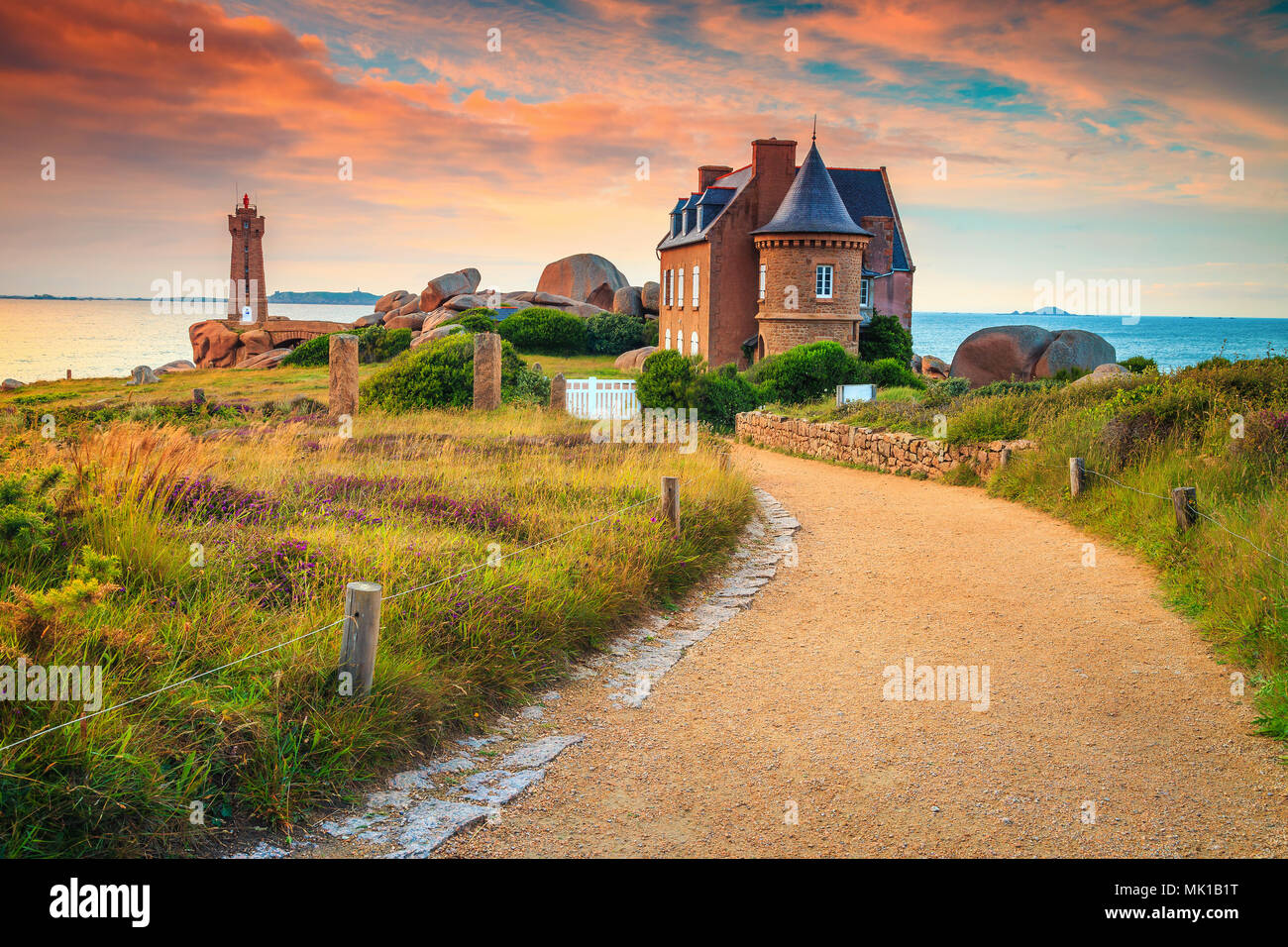 Atemberaubenden Sonnenuntergang mit Leuchtturm und Luxus Villa, Ploumanach, Ruz in Perros-Guirec auf rosa Granit Küste, Bretagne, Frankreich, Europa Stockfoto