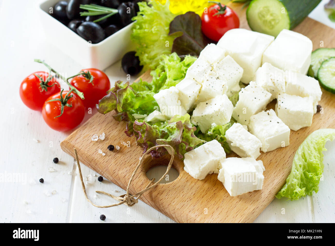 Feta Käse und schwarzen Oliven, Kochen qreek Salat mit frischem Gemüse auf einem weißen Holztisch. Stockfoto