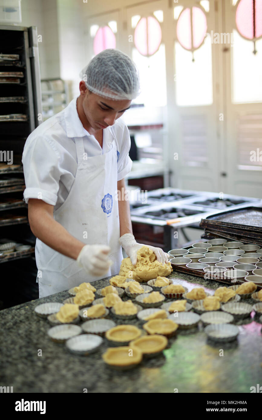 Ein Bäcker, der in der Küche der Confeitaria Colombo, Rio de Janeiro, Brasilien portugiesische Pfandtarts (Pasteis de nata) vorbereitet Stockfoto