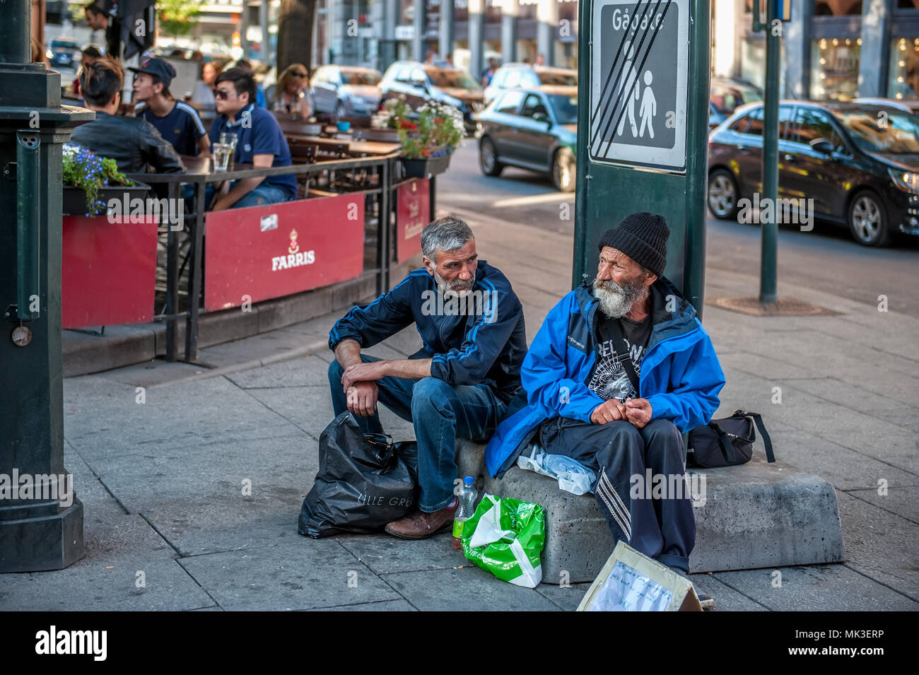 Norwegen, Oslo August 01 2013. Zwei ältere Männer fragen für Almosen, saß auf der Straße vor dem Café. Das Konzept der Indifferenz des Staates zu den Stockfoto