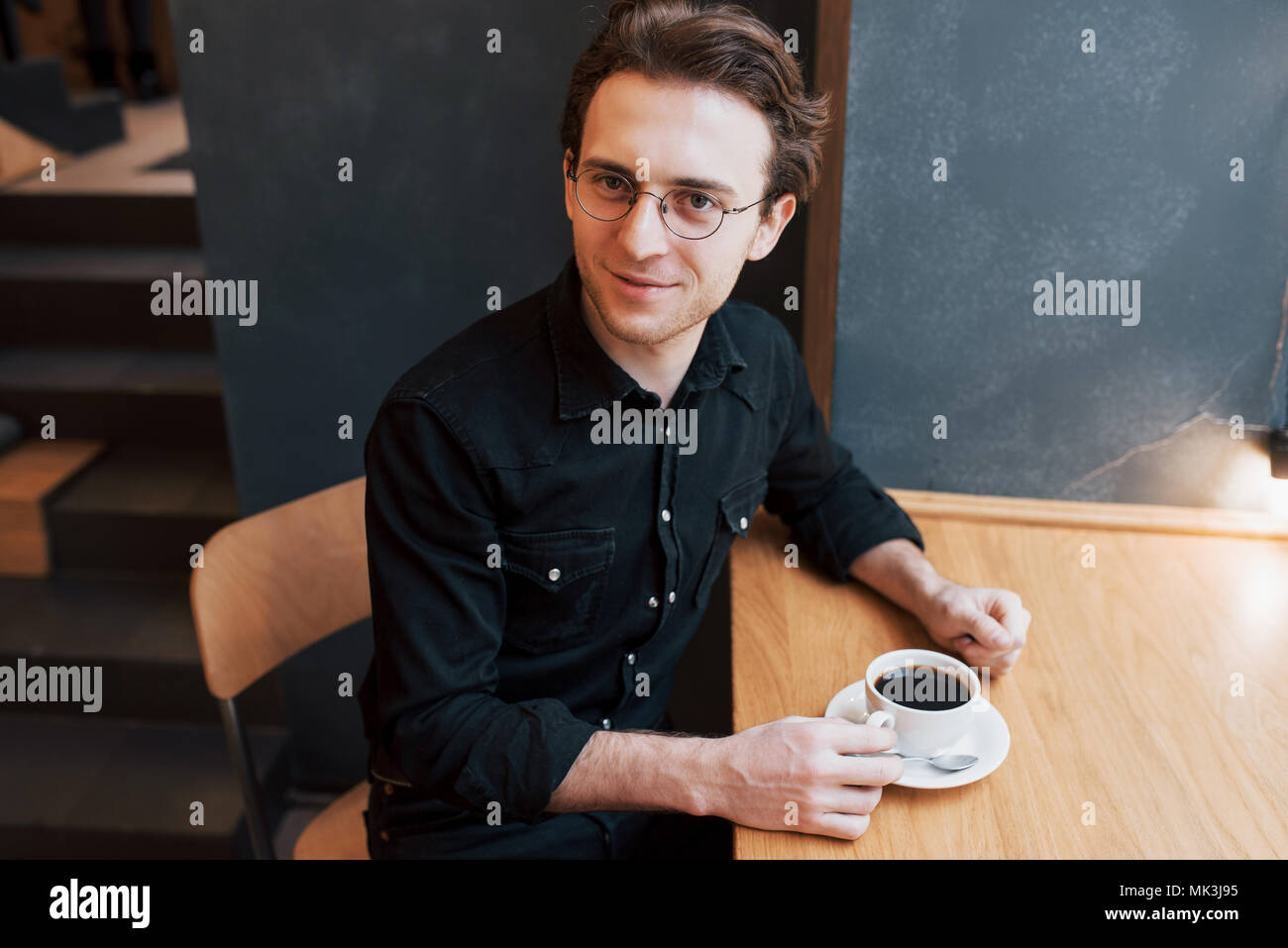 Bärtiger Mann kariertes Hemd mit Gabel Essen im Café und Blick in die Kamera Lächeln Stockfoto