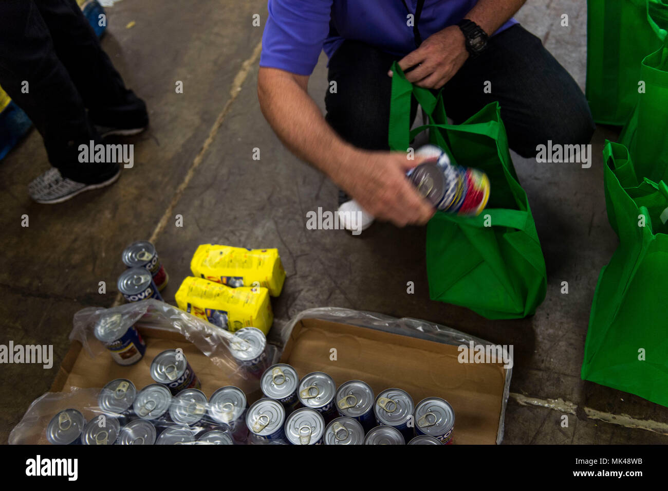 Freiwillige mit der Federal Emergency Management Agency, des amerikanischen Roten Kreuzes und Freiwillige vor Ort, erstellen Sie ein neues Paket liefert in Säcke mit Reis, Bohnen und anderen Waren für die Bewohner von Comerio, Puerto Rico in der lokalen Gemeinde Lager, Sept. 17, 2017. Nach dem liefert umgepackt, die lokale Regierung wird es für die Bewohner von Hurrikan Maria gestört. (U.S. Air Force Foto von Airman 1st Class Nicholas Dutton) Stockfoto