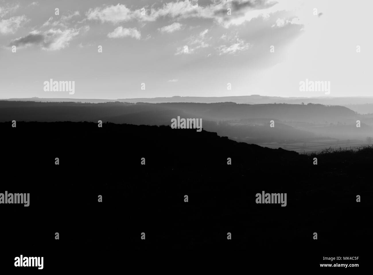 Eine schwarze und weiße Landschaft schoss mit Blick über das Tal bei Curbar Kante im Peak District, ENGLAND Stockfoto