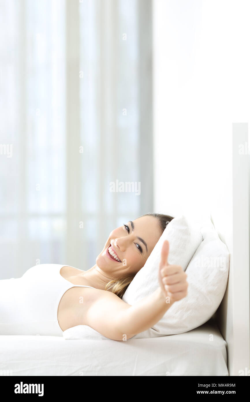 Vertikale comporition einer Frau Gestik Daumen hoch liegen auf einem Bett zu  Hause Stockfotografie - Alamy