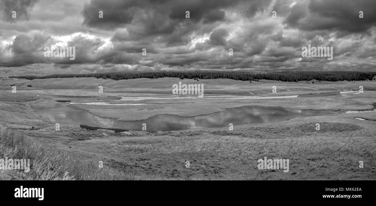 Sturmwolken wie ein Gewitter über dem Fluss Formen, schwarz-weiß-Bild. Stockfoto