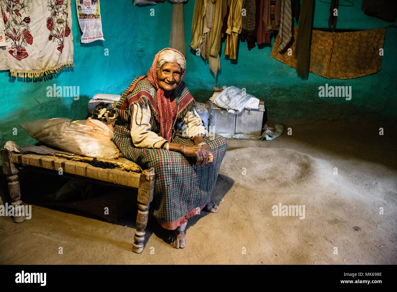 Alte indische Frau auf einem charpoy Bett in ihrem Haus in Naggar, Himachal Pradesh, Indien sitzen Stockfoto