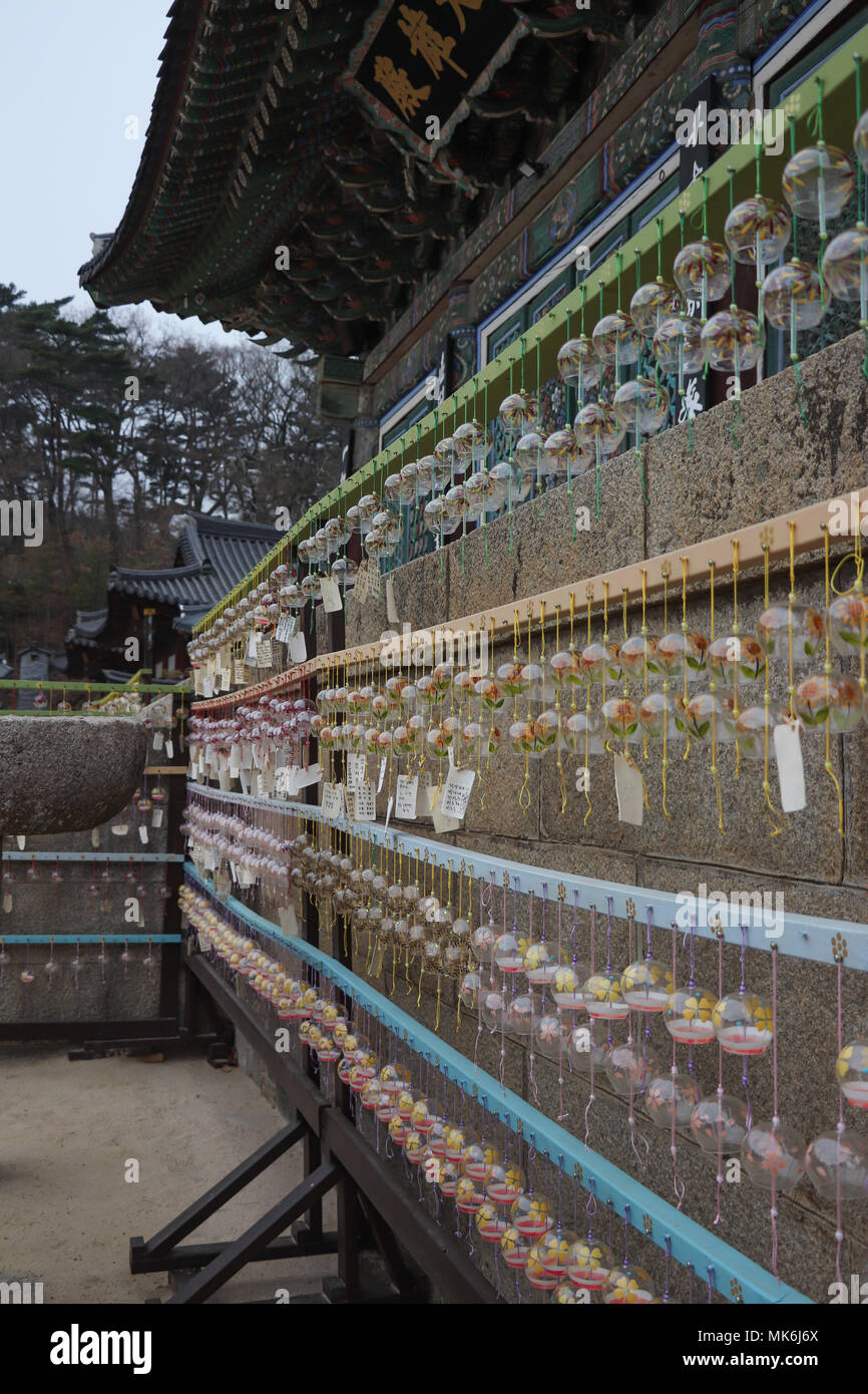 Eine Wand des votiv Glas Glocken mit Wünschen tags hängend an einem Rack durch die Haupthalle, die Daeung - Jeon, an der Donghwasa Tempel in der Nähe von Daegu, Südkorea. Stockfoto