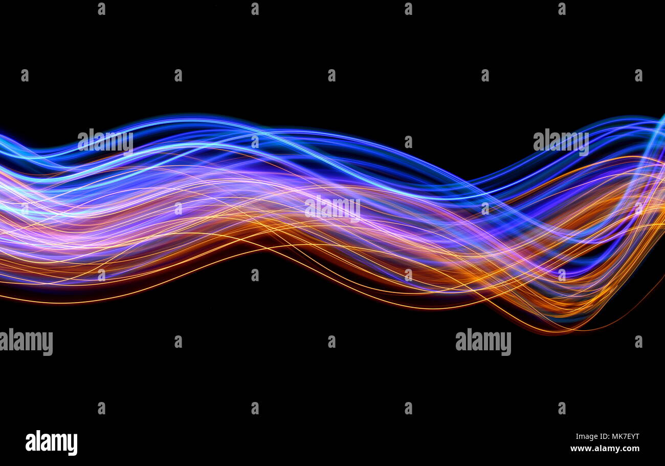 Blau und Gold Licht Malerei Fotografie, lange Belichtung Foto von farbige Lichterketten in Wirbel und Wellen, gegen einen sauberen schwarzen Hintergrund Stockfoto