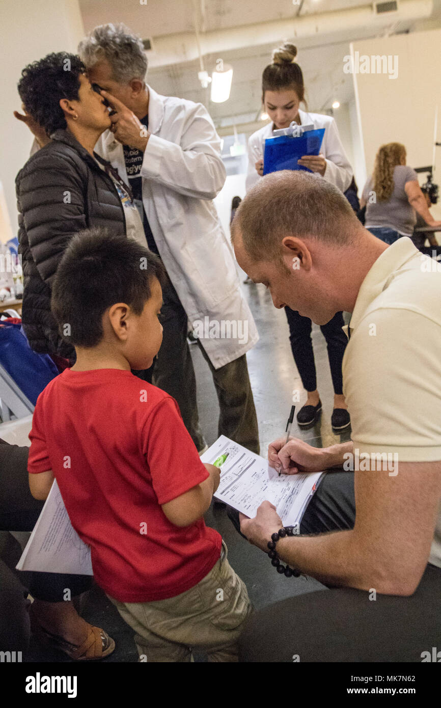 Us-Armee finden Sgt. Brendan Irland, ein optometrie Techniker, geht über einen Vision-fitness test mit Justin Vasquez, 3, in der Betreuung Hafen in Los Angeles, Calif., Nov. 18, 2017. Irland, ist eines von Dutzenden von Armee-reserve Soldaten aus der 7214Th medizinische Unterstützung in Los Alamitos, Calif., stationiert, die ihre Zeit und ihren medizinischen Know-how freiwillig helfen Kostenlose Versorgung für die Bürger von Los Angeles bieten; viele von ihnen haben keinen Zugang zu medizinischer Versorgung. (U.S. Armee Foto: Staff Sgt. Felix R. Fimbres) Stockfoto