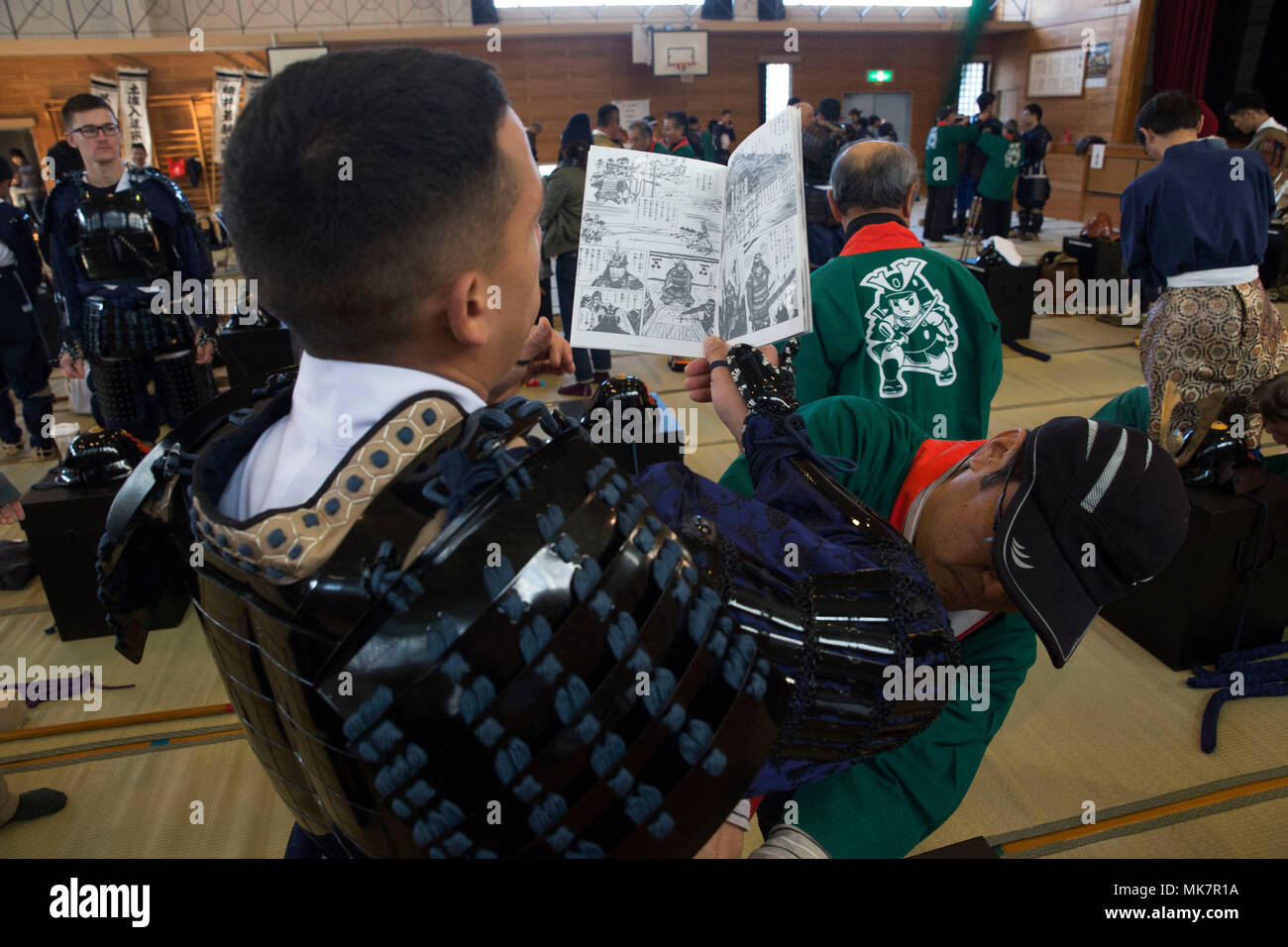 Us Marine Corps Cpl. Carlos Jimenez, ein Kampf der Communicator mit Sitz und Hauptverwaltung Squadron, Marine Corps Air Station Iwakuni (WAB), Japan, liest eine informative Broschüre während des 28. jährlichen Kuragake Festival und Samurai Parade in der Stadt Iwakuni, Japan, November 19, 2017. Marines von WAB Iwakuni wurden eingeladen, an der historischen Parade teilzunehmen, als traditionelle Samurai. Der Service Mitglieder marschierten neben lokalen Japanischen der Große gegen eine Untreue Verbündete zu gedenken. (U.S. Marine Corps Foto von Sgt. N.W. Huertas) Stockfoto