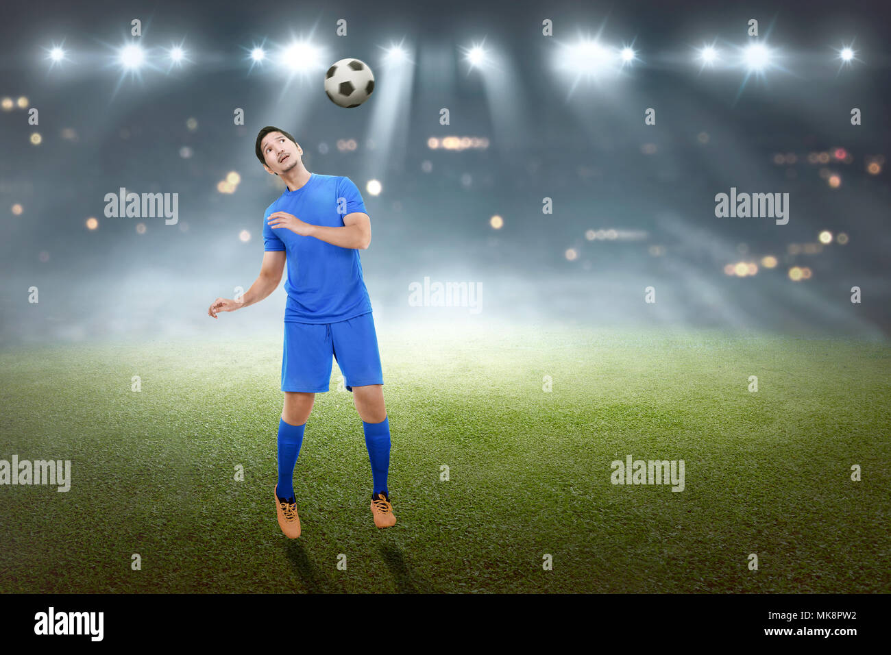 Schönen asiatischen männlich Fußball Spieler versucht zu Position die Kugel im Spiel Stockfoto