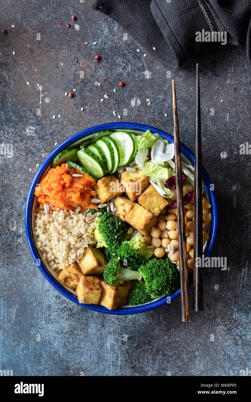 Salat mit Quinoa, Tofu, Brokkoli, Kichererbsen und Gemüse. Buddha Schüssel auf dunklem Hintergrund. Bunte vegetarische Buddha Schüssel. Nähren Salatschüssel, Tabl Stockfoto