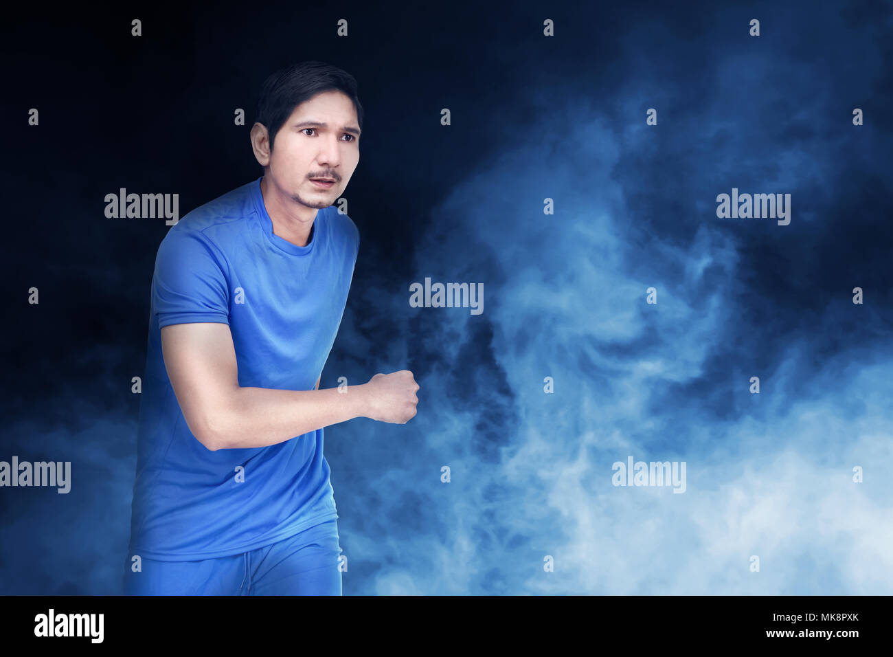 Schönen asiatischen Fußball-Spieler Mann mit blauen Jersey über abstrakt Hintergrund Stockfoto