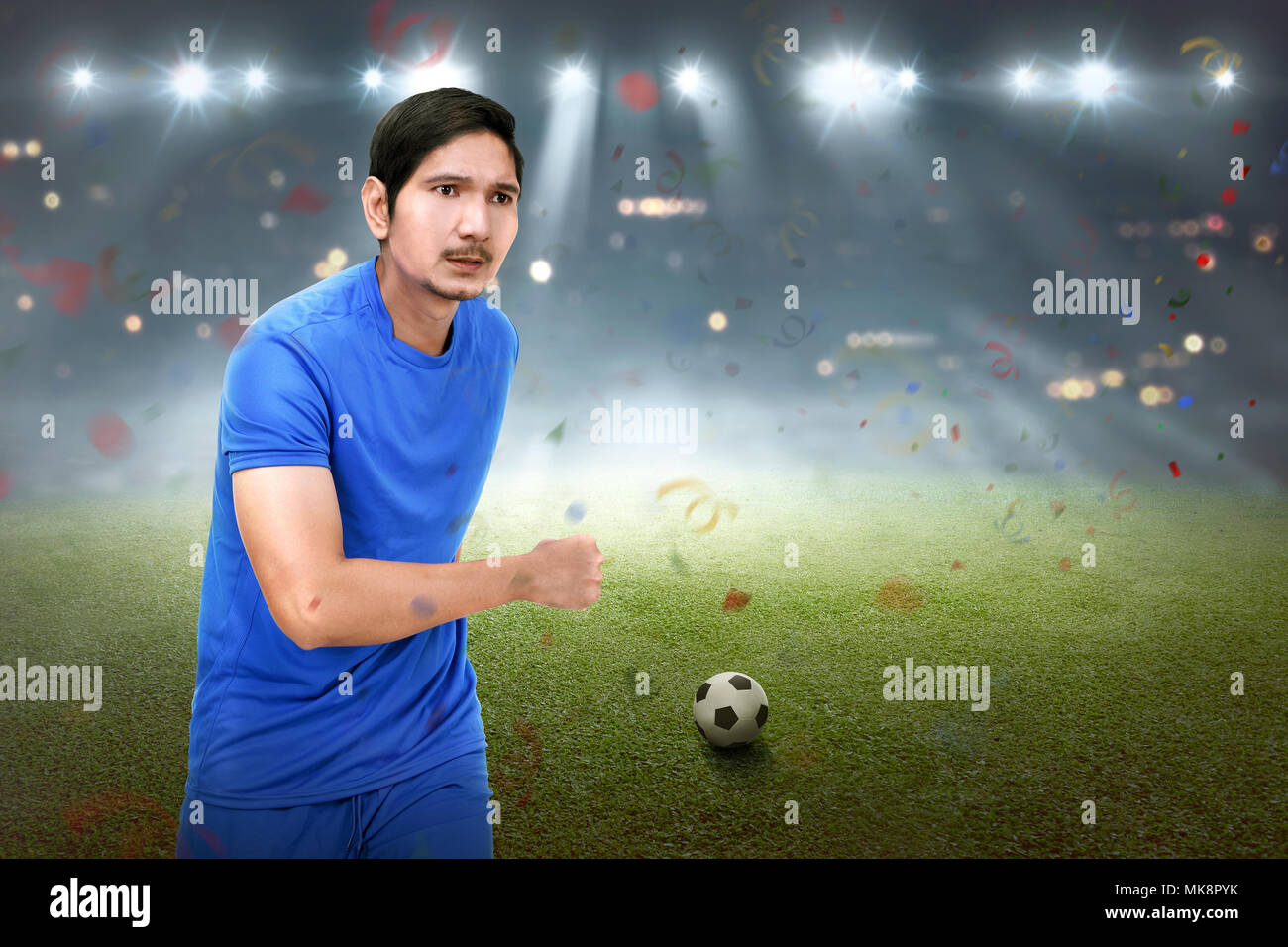 Attraktiven asiatischen Fußball-Spieler mann Laufen mit dem Ball auf dem Feld Stockfoto