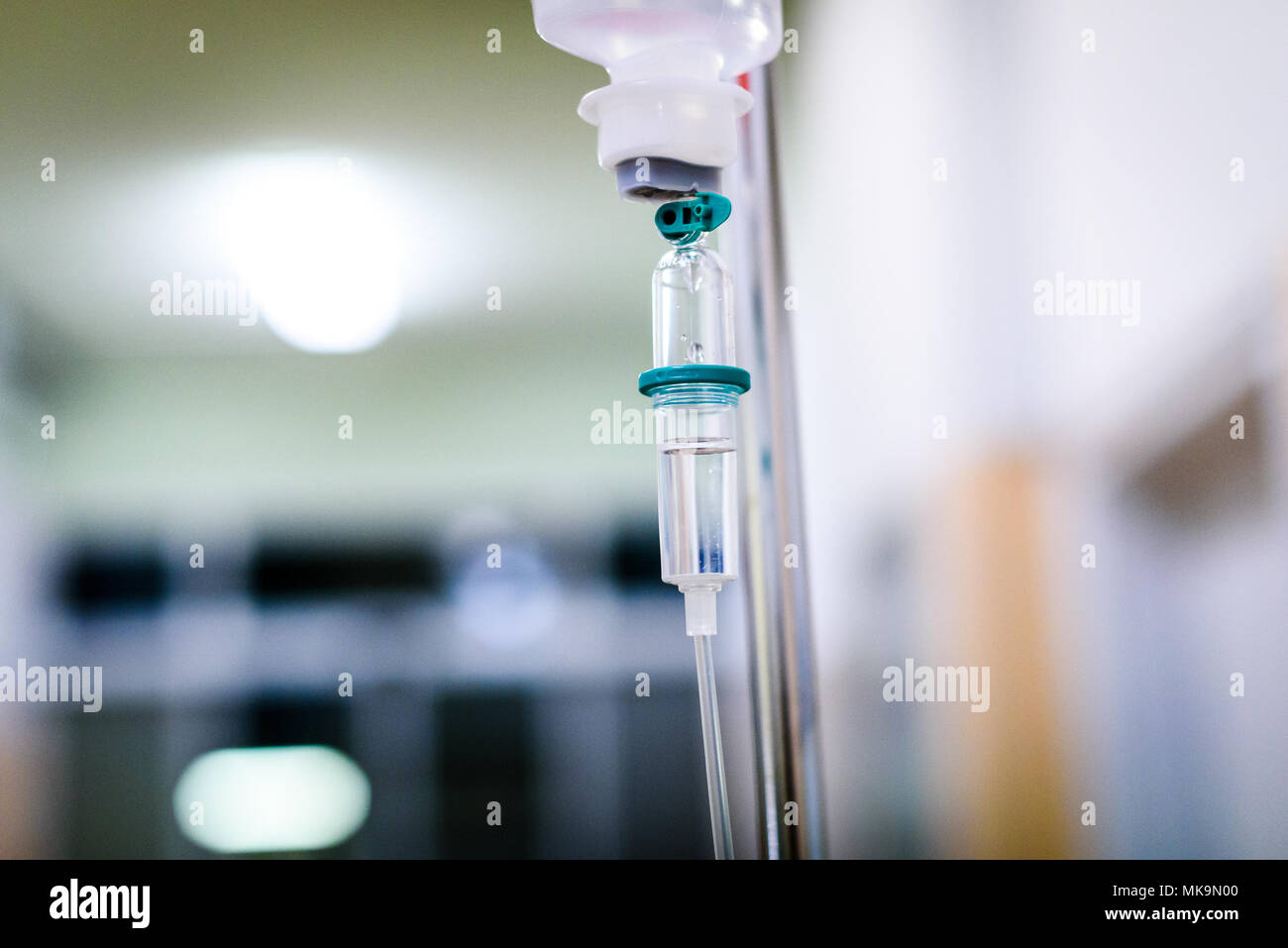 Mit der intravenösen Behandlung iv-Infusion und Flasche auf einer Stange. Flüssige Kochsalzlösung langsam Tropfen Tropfen Drogen, Arzneimittel oder antibiotische Therapie und Chirurgie Stockfoto
