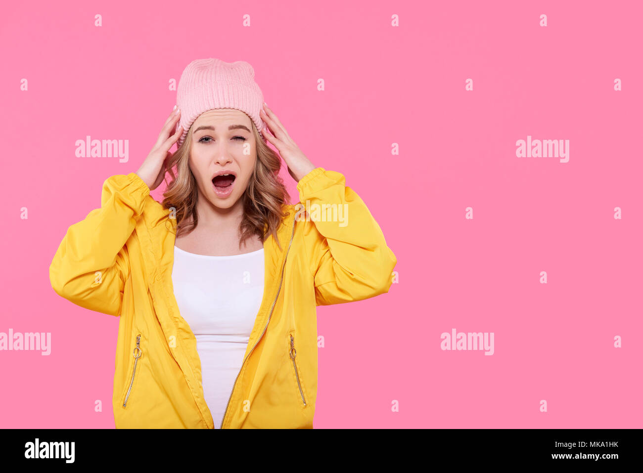 Schön verrückt Hipster girl Teenager mit Kopf in den Händen und offenen Mund, im Schock schreiend. Überrascht, Frau, die Geste. Studio Portrait ove Stockfoto