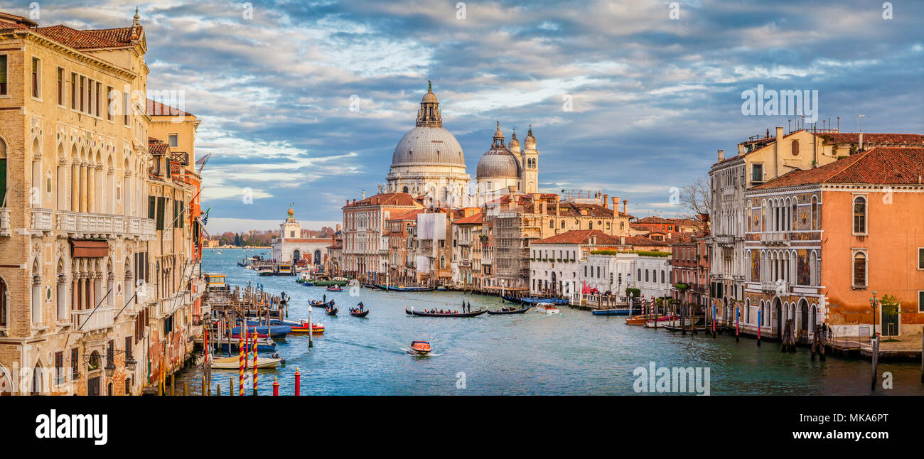 Klassische Ansicht der berühmten Canal Grande mit malerischen Basilika di Santa Maria della Salute in wunderschönen goldenen Abendlicht bei Sonnenuntergang, Venedig, Italien Stockfoto