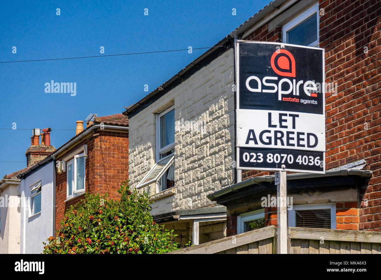 Lassen Sie Zeichen außerhalb einer Reihe von Häusern in einer Wohnstraße vereinbart, Wohnungsmarkt Konzept, England, Großbritannien Stockfoto