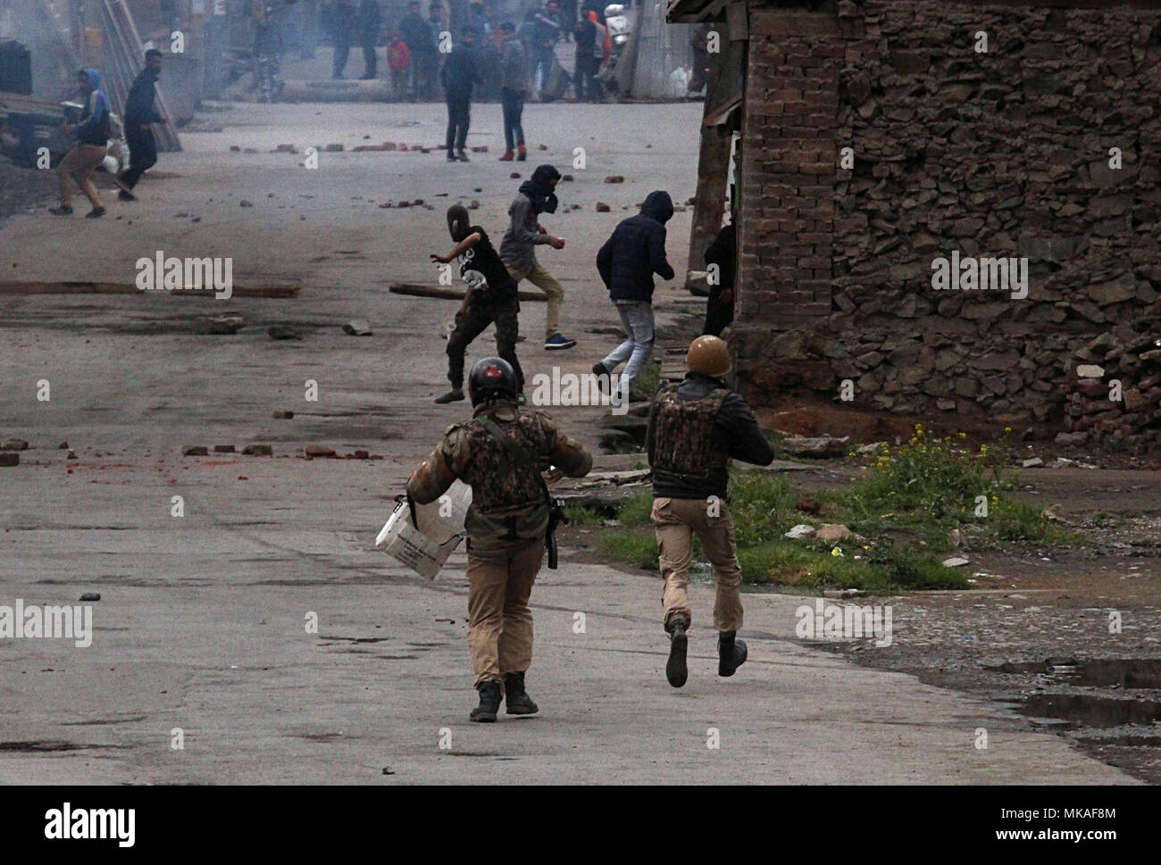 Kaschmir. 7. Mai, 2018. Indische Polizisten Feuer reissen Rauch Kanister pro Freiheit Demonstranten in Srinagar, Kashmir am Mai 07, 2018 zu zerstreuen. Die Polizei feuerte Tränengas Kanister, Pellets und Blendgranaten der wütenden Menge zu zerstreuen. Massive anti-Indien Auseinandersetzungen in Srinagar nach der Ermordung von 10 Menschen, darunter fünf Rebellen und fünf Zivilisten durch indische Sicherheitskräfte in Kaschmir ausbrechen. Credit: Faisal Khan/ZUMA Draht/Alamy leben Nachrichten Stockfoto