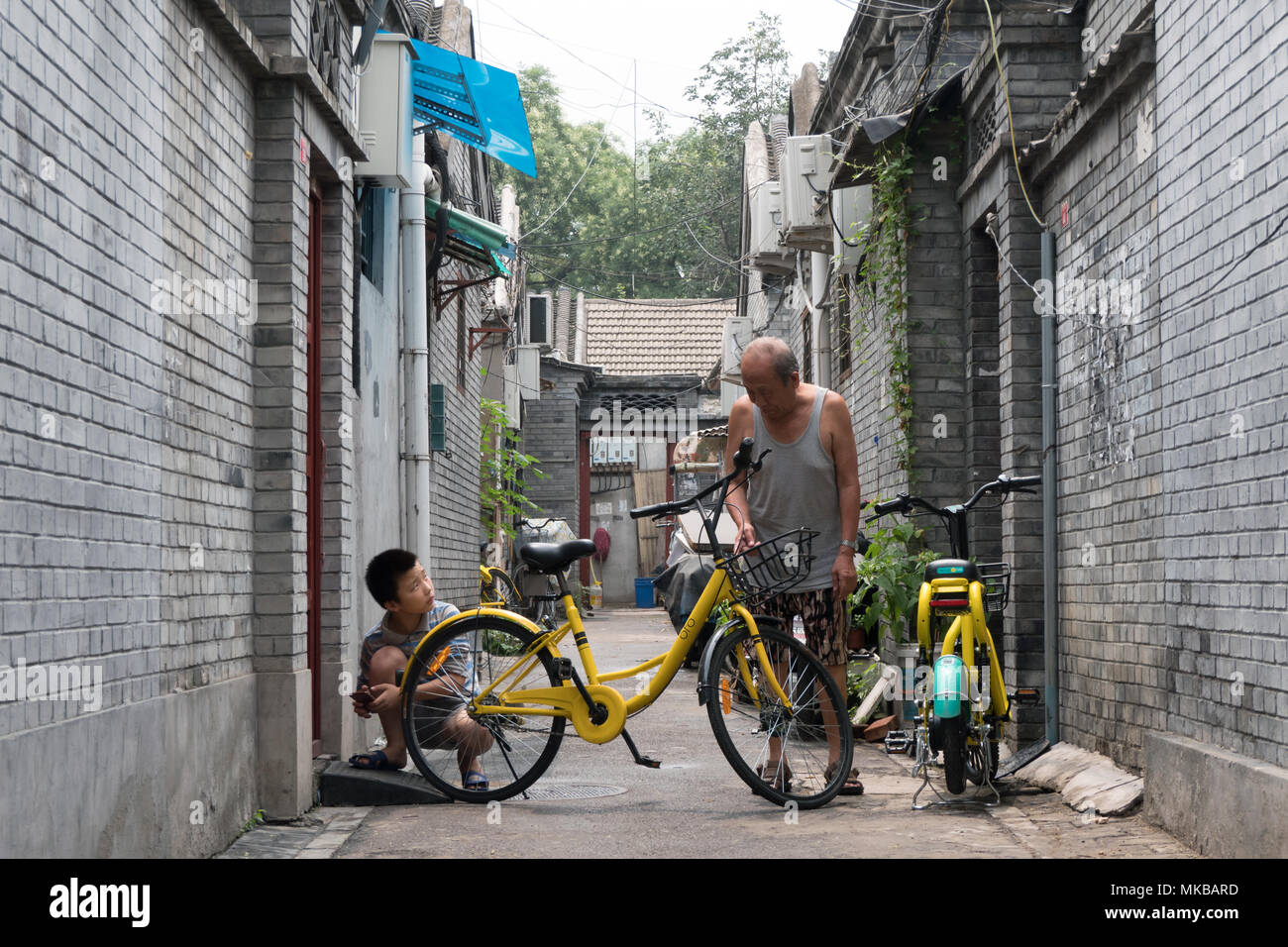 Der Alltag in einem Hutong (traditionelle Alte Gasse) von Peking, China, Asien. Alter Mann im Gespräch mit Jungen Stockfoto