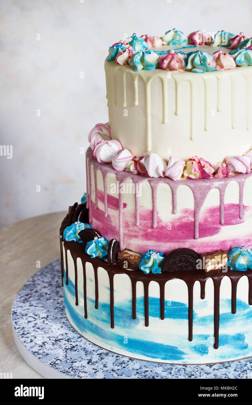 Dreistufige farbige Kuchen mit farbigen Flecken von Schokolade auf einem hellen Hintergrund. Bild für ein Menü oder ein süsswaren Katalog mit Kopie Raum Stockfoto