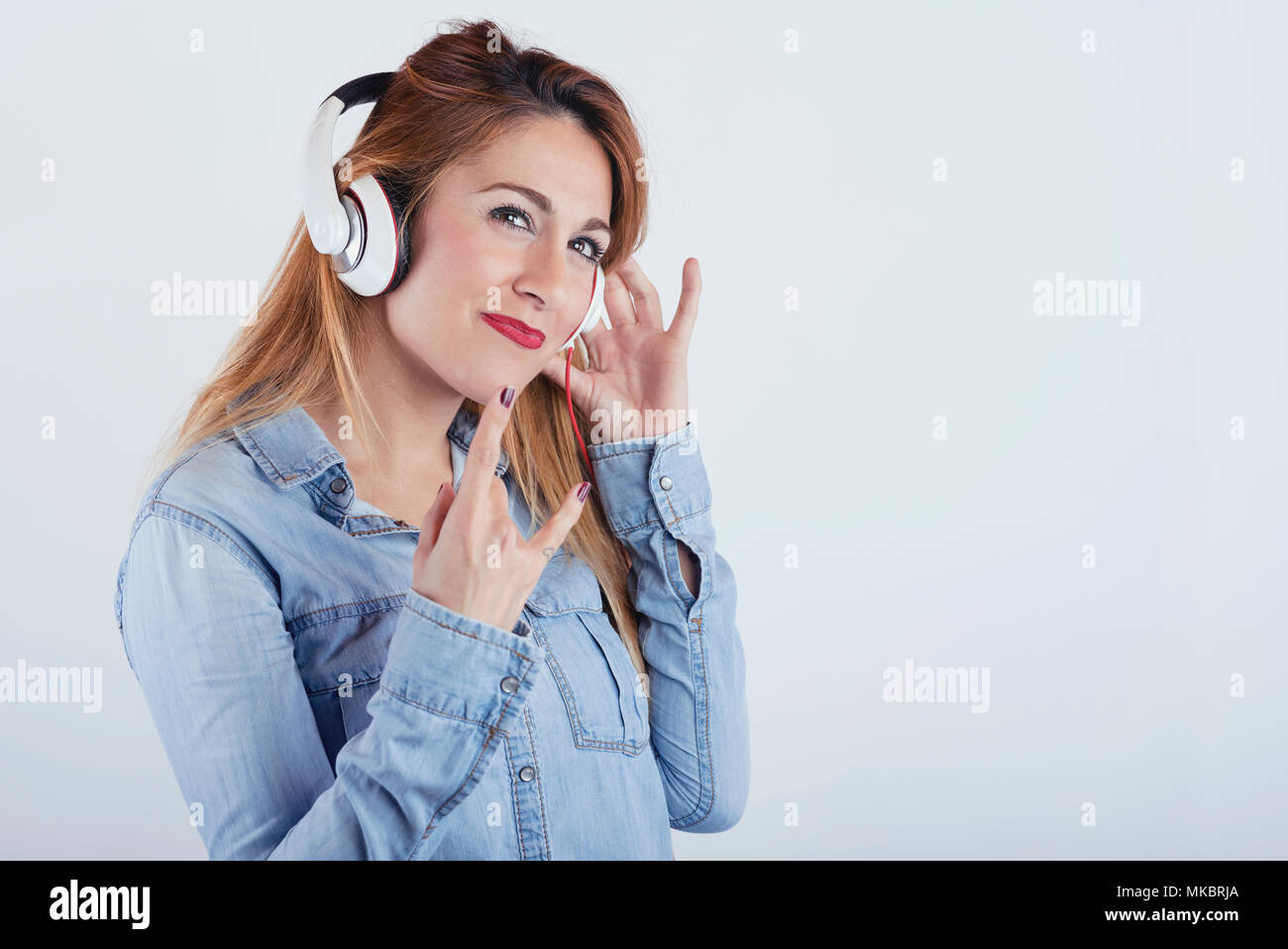 Glückliche junge Frau mit Kopfhörer auf weißem Hintergrund Stockfoto