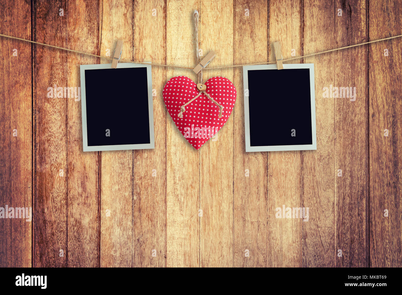 Leere instant Fotos und roten Herzen hängen auf Holz- Hintergrund. Stockfoto