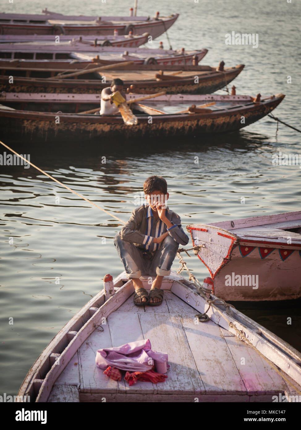 Wie jeder geht über Ihre morgen Chores in Varanasi, diesem jungen Mann träumt von anderswo. Stockfoto