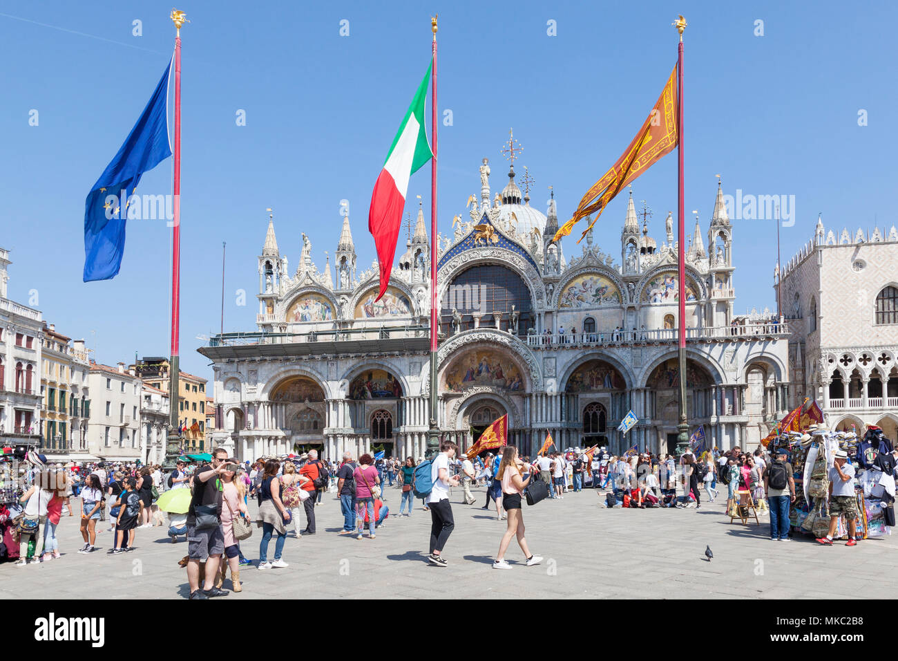 Basilika San Marco (Markusplatz Kathedrale) an der Piazza San Marco (Markusplatz) mit den Flaggen von Venedig, in der EU und in Italien fliegen am Tag der Befreiung, Venedig Stockfoto