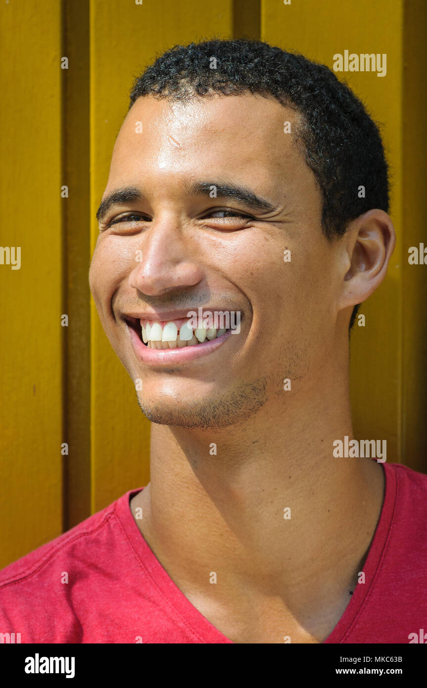 Porträt eines afrikanischen amerikanischen Mann mit einem großen Lächeln auf eine gelbe Wand Hintergrund Stockfoto