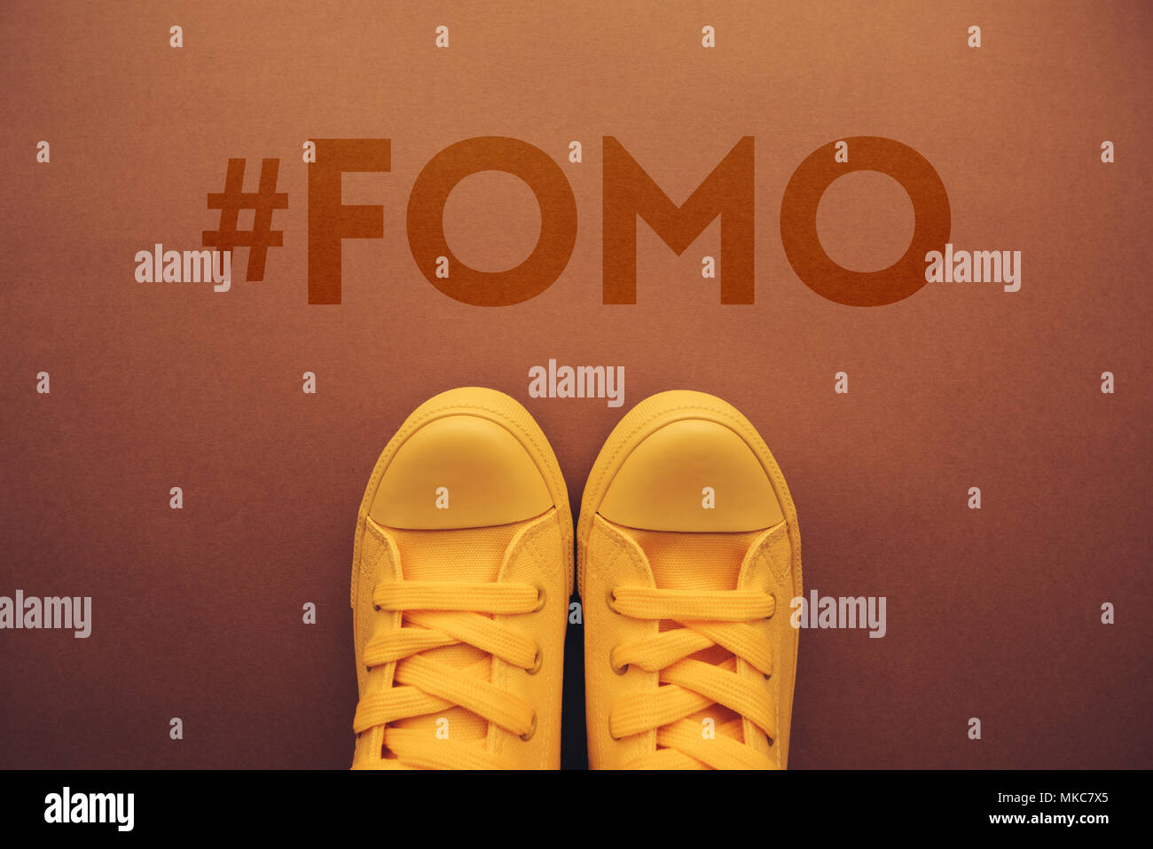FOMO, Angst, fehlende Konzept mit gelben Turnschuhen von oben. Stockfoto