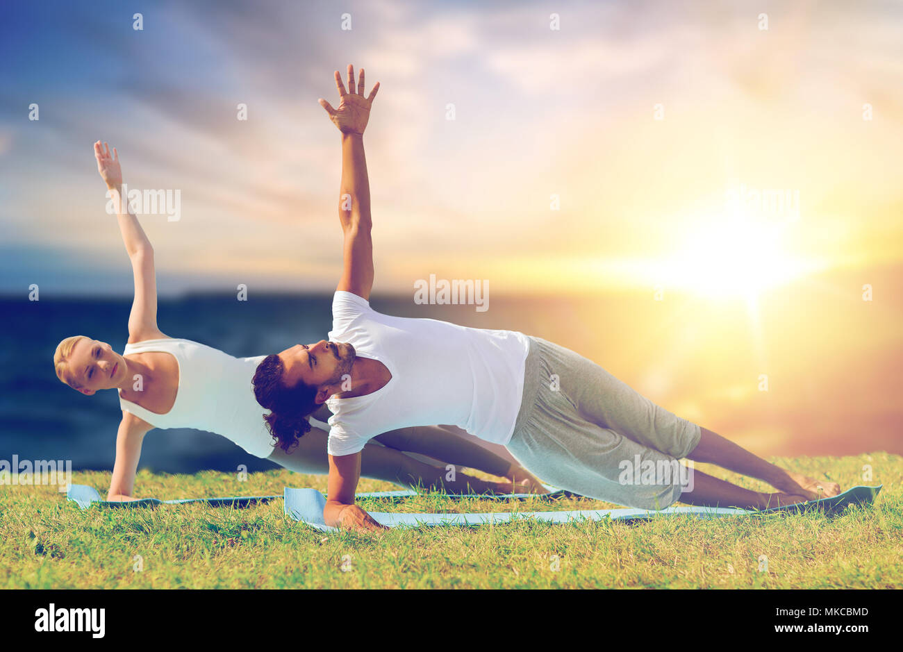 Paar Yoga und seitlicher Ganzkörperstütz im Freien Stockfoto