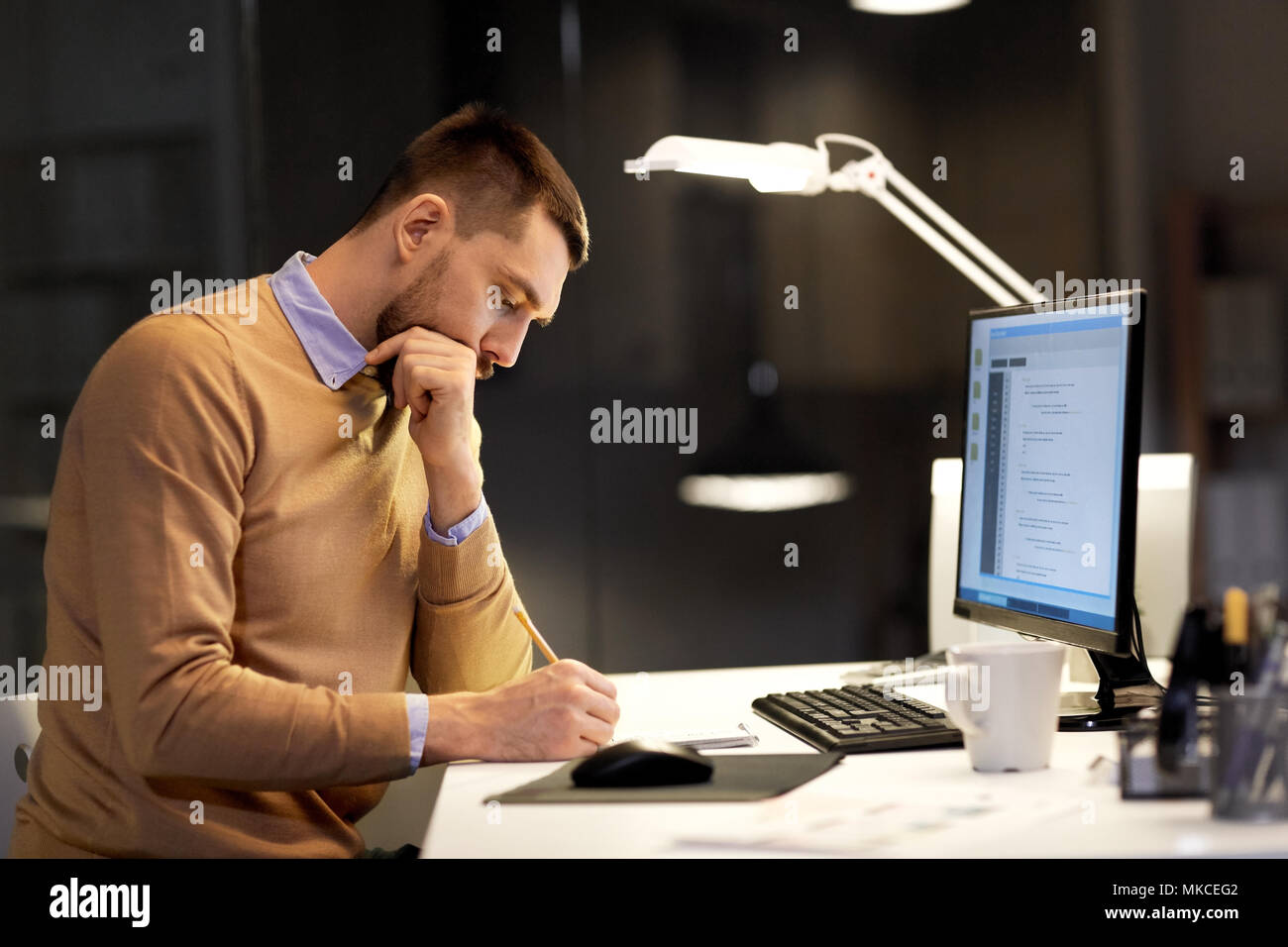 Mann mit Notepad arbeiten an Code in der Nacht Büro Stockfoto