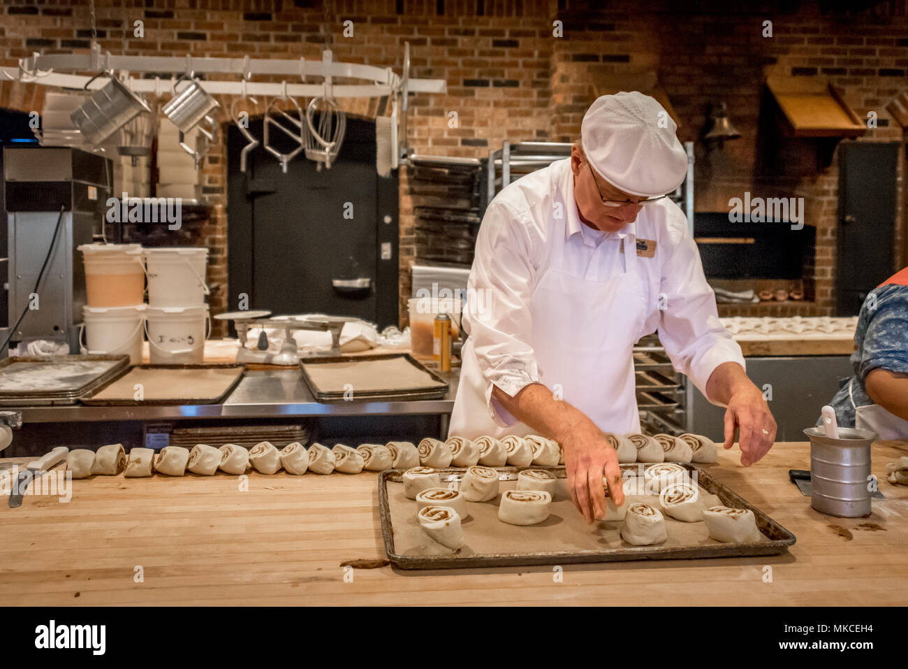 Ein Bäcker macht Zimtschnecken bei Eva und Delilah Bäckerei in Silver Dollar City, einem beliebten Reiseziel in Branson, Missouri, in der Küche dargestellt. Stockfoto