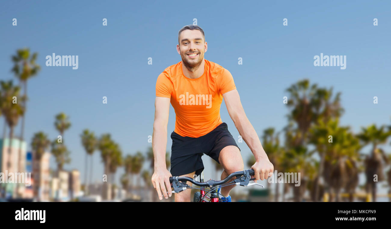 Glückliche junge Mann reiten Fahrrad über Strand Venedig Stockfoto