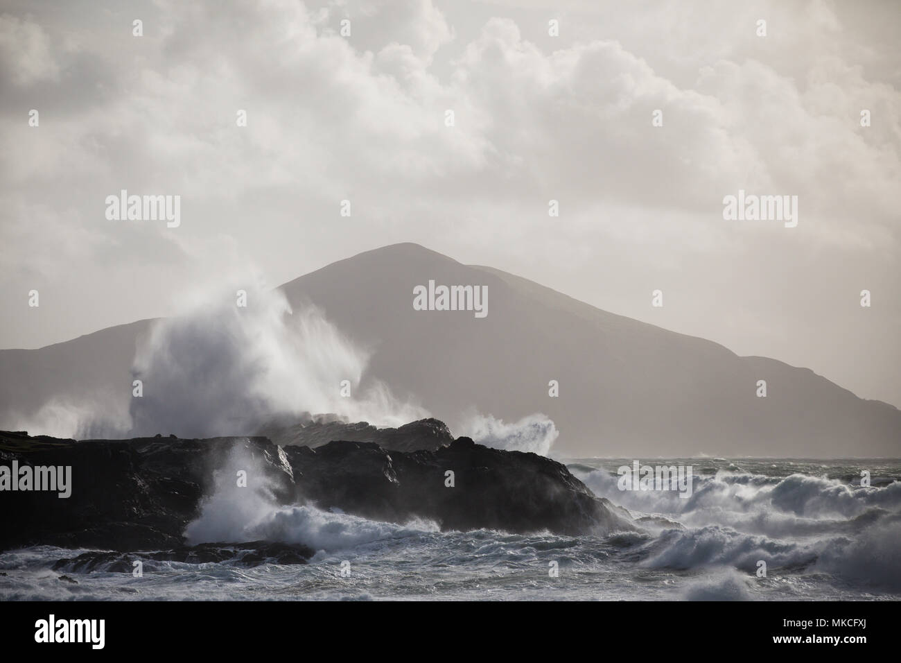 Wellen an der Küste von Achill Island, County Mayo Irland mit Clare Insel im Hintergrund zu brechen. Stockfoto