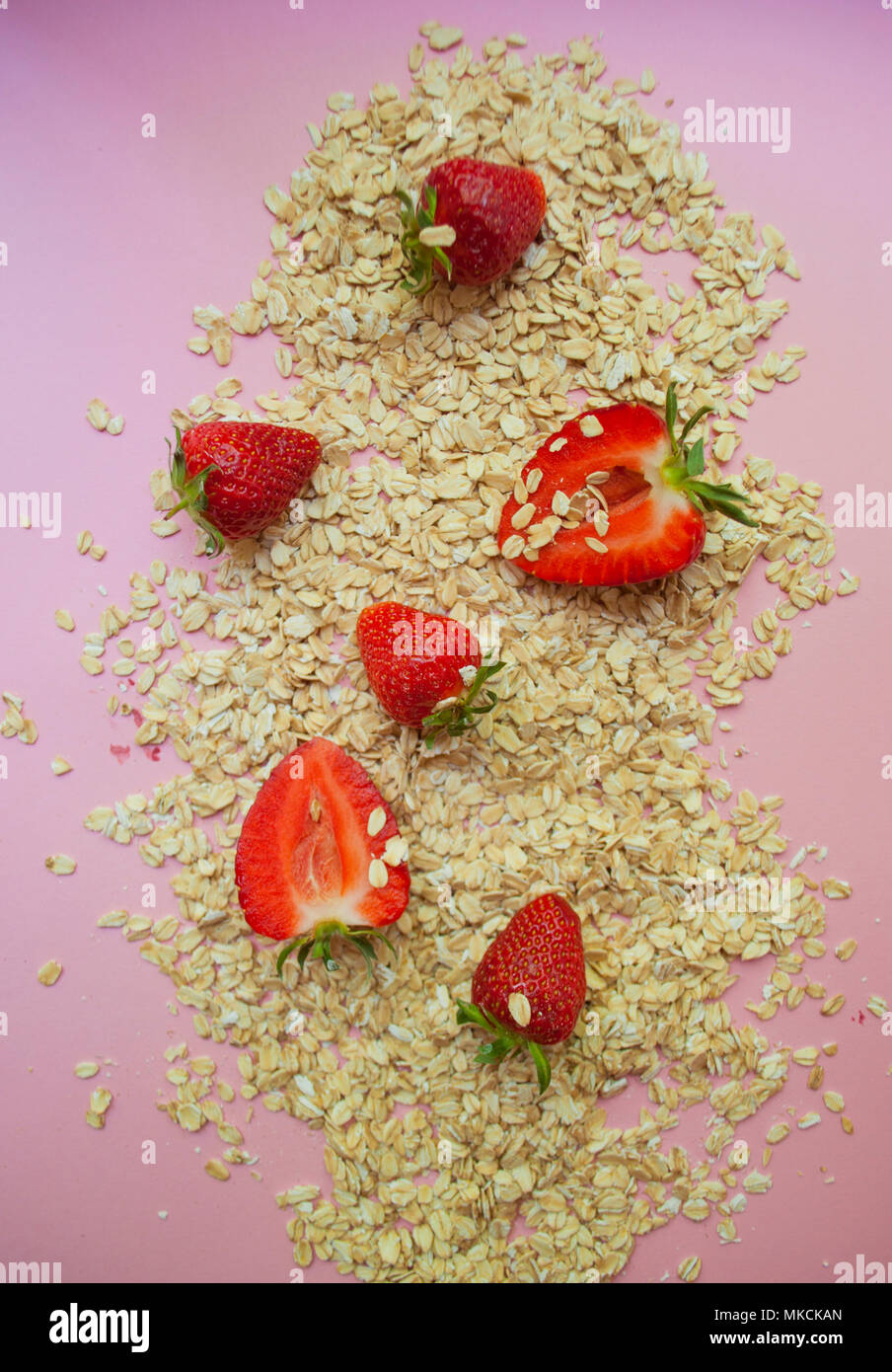 Strawberryand Haferflocken auf rosa Hintergrund. Stockfoto