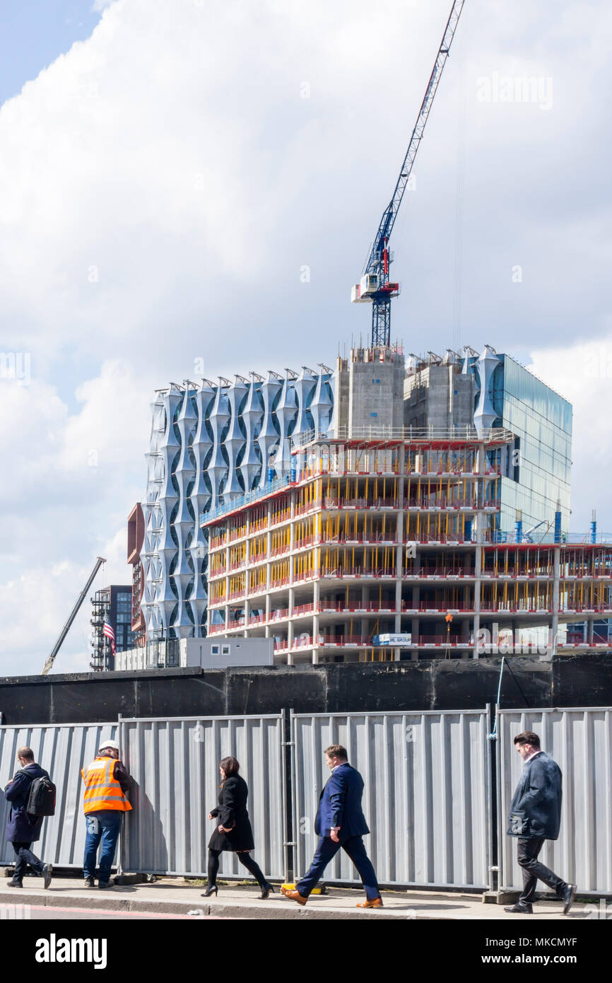 Menschen zu Fuß Vergangenheit Baustelle horten bei Nine Elms mit dem Bau der neuen amerikanischen Botschaft im Hintergrund. Stockfoto