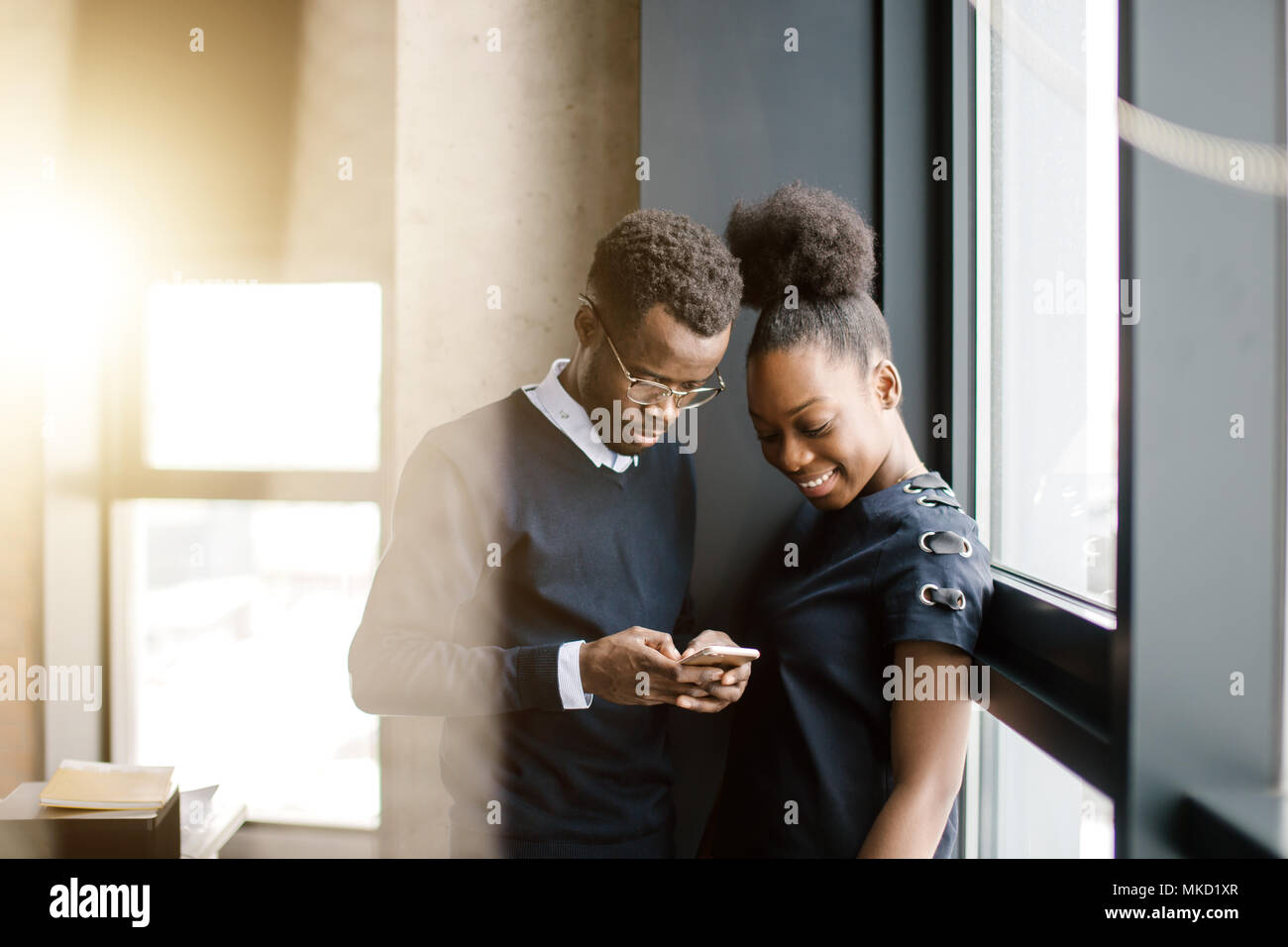Freundliche Mitarbeiter erhalten Informationen aus dem Handy. Bilder senden, Video Stockfoto
