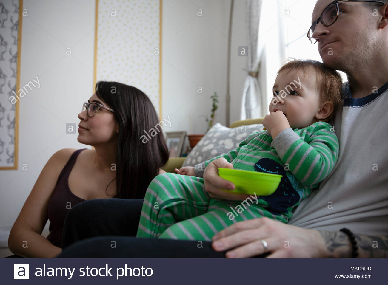Junge Familie essen, Fernsehen Stockfoto