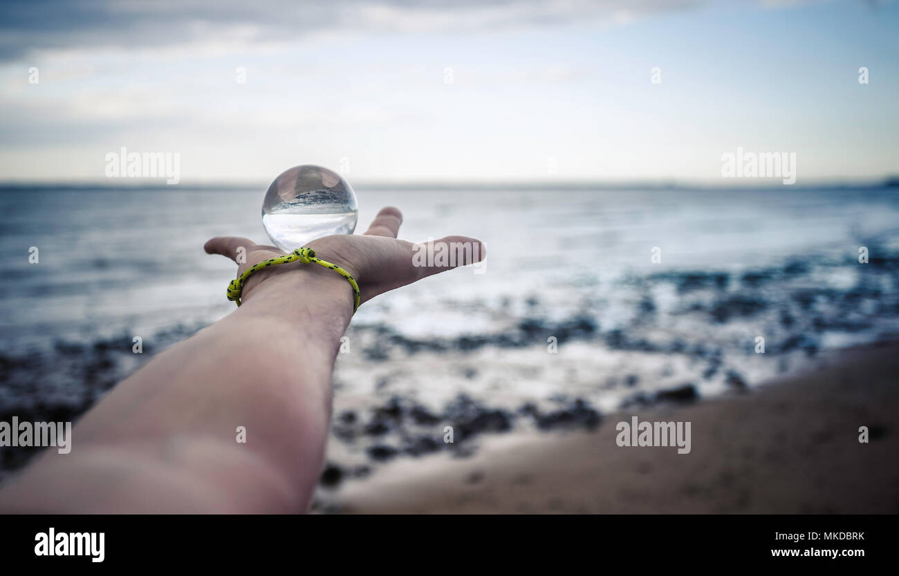 Crystal Ball an Hand des jungen Mannes Stockfoto