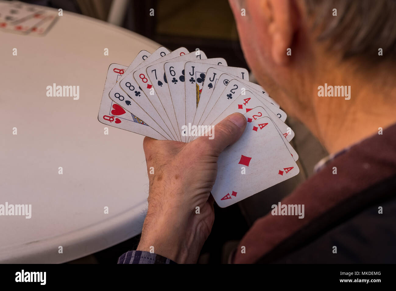 ASCIANO, Toskana, Italien - 25 April 2018: Asciano mit Schluchten, Farmen in einer rauen Landschaft, unbekannter Mann spielt Karten Stockfoto