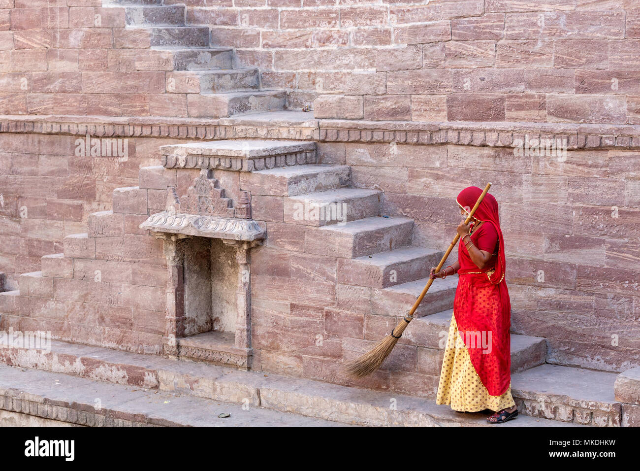 Frau im Sari Reinigung die Schritte bei Toorji Ka Jhalara, der Schritt gut, Jodhpur, Rajasthan, Indien Stockfoto