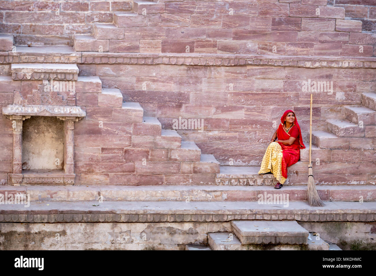 Frau im Sari ruht auf die Stufen am Toorji Ka Jhalara, der Schritt gut, Jodhpur, Rajasthan, Indien Stockfoto