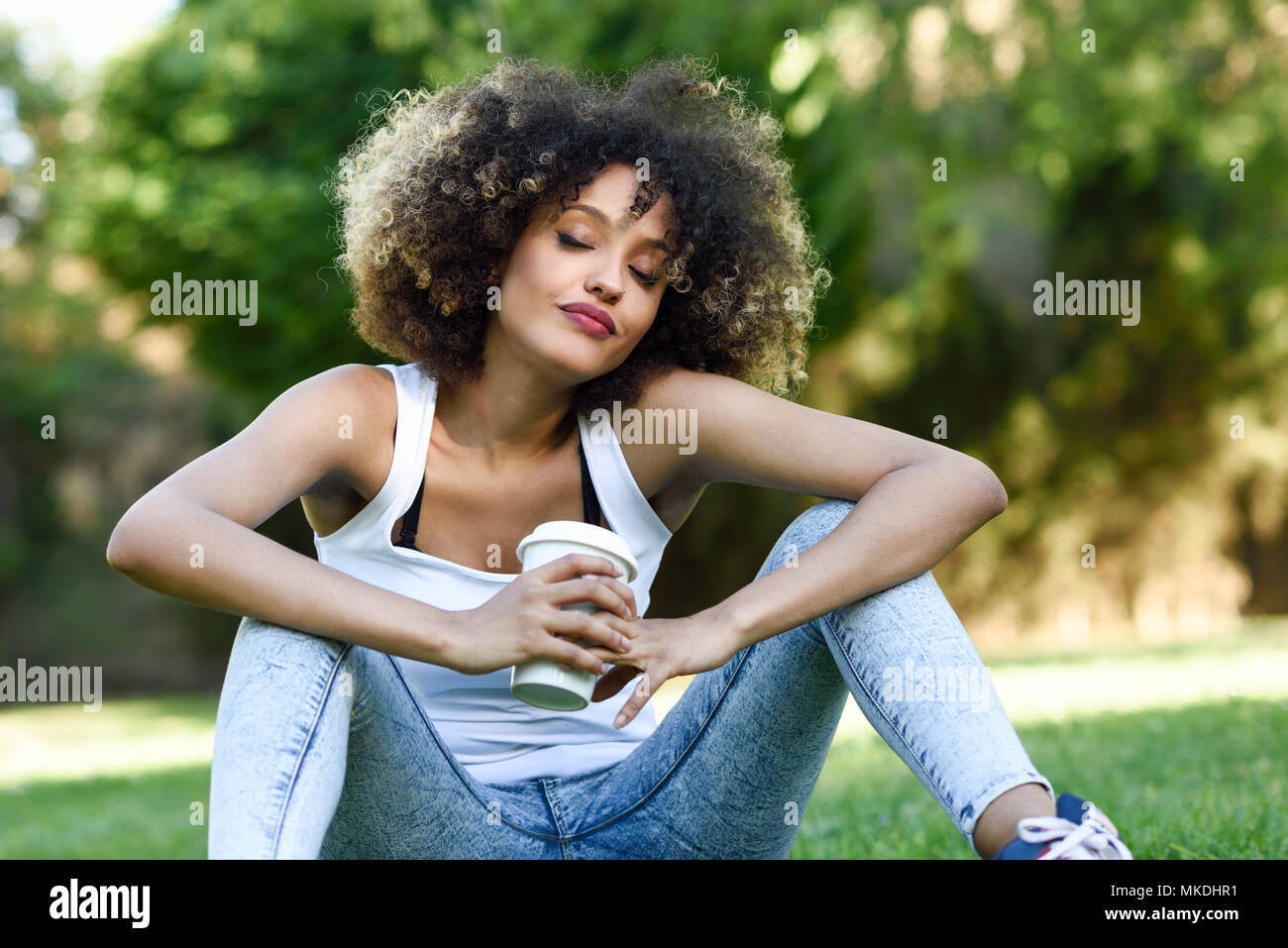 Schone Junge Afrikanische Amerikanische Frau Mit Afro Frisur Madchen Traumen Mit Geschlossenen Augen Mit Ein Glas Im Park Sitzen Auf Gras Tragen Kann Stockfotografie Alamy