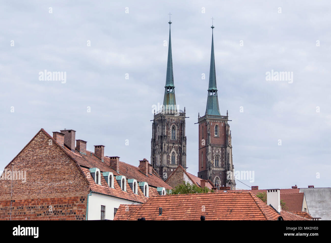 Zwei hohe Türme der Kathedrale im gotischen Stil. Hauptfassade und Ziegelgebäude. Dom St. Johannes der Täufer in Wroclaw, Polen. Stockfoto