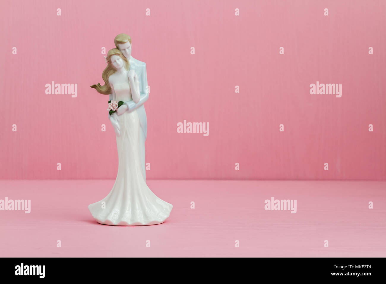 Hochzeit paar Figürchen auf rosa Hintergrund Holz Stockfoto